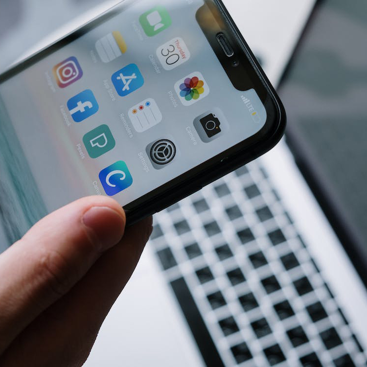 Someone using a mobile phone and a laptop