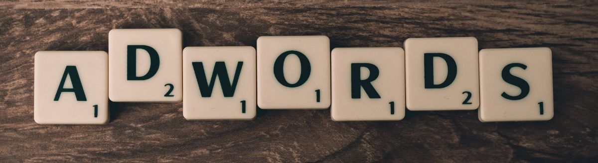 Scrabble Forming Adwords on Brown Wooden Surface